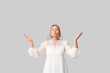 Adult woman outstretching hands on white background. Praying concept