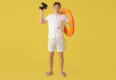 Photo for Male lifeguard with binoculars and lifebuoy ring on yellow background - Royalty Free Image