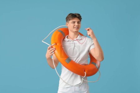 Photo for Male lifeguard with lifebuoy ring and whistle on blue background - Royalty Free Image