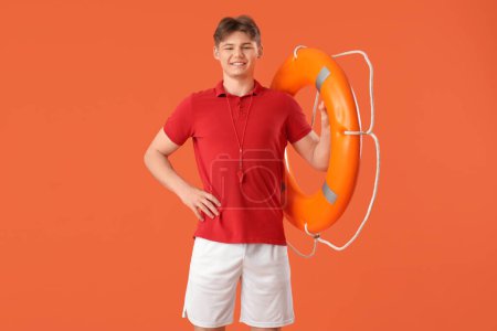 Photo for Male lifeguard with ring buoy on orange background - Royalty Free Image