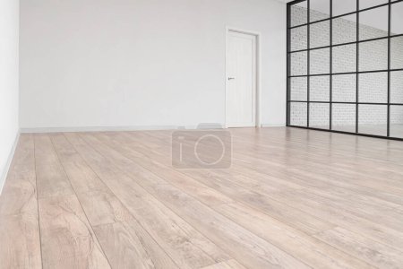 Téléchargez les photos : Vue de la grande pièce vide avec nouveau stratifié en bois, écran pliant et porte - en image libre de droit
