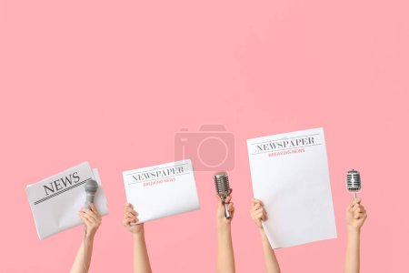 Téléchargez les photos : Mains féminines avec journaux et microphones sur fond rose - en image libre de droit