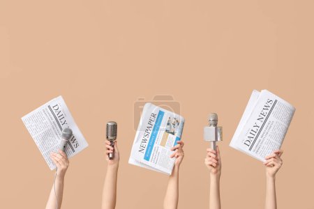 Téléchargez les photos : Mains féminines avec microphones et journaux sur fond de couleur - en image libre de droit