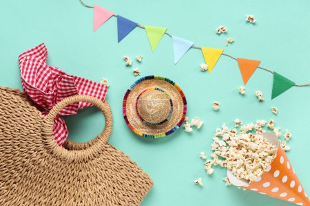 Komposition mit stilvoller Korbtasche, Popcorn und Fahnen für die Festa Junina auf farbigem Hintergrund