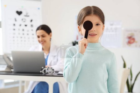 Petite fille avec occlusion oculaire à la clinique