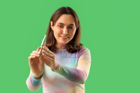 Téléchargez les photos : Jeune femme avec cigare électronique sur fond vert, gros plan - en image libre de droit