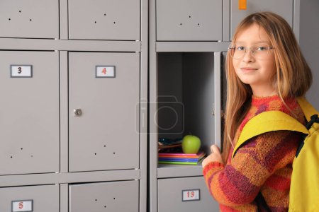Photo for Little schoolgirl opening her locker at school - Royalty Free Image