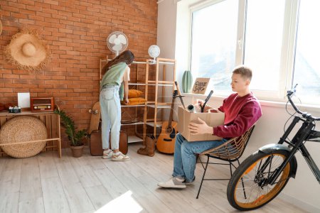 Photo for Young couple with unwanted stuff in room - Royalty Free Image
