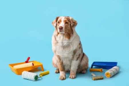 Netter Hund und Dekorationswerkzeuge auf blauem Hintergrund