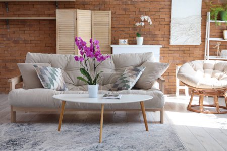 Téléchargez les photos : Intérieur du salon avec canapé, fauteuil et fleur d'orchidée sur la table - en image libre de droit