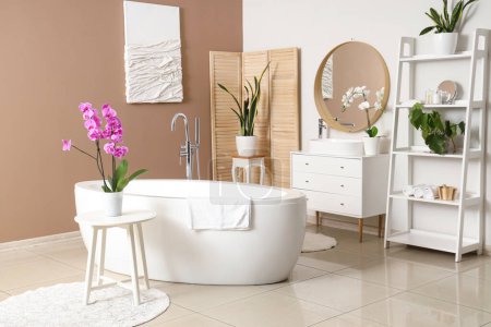 Téléchargez les photos : Intérieur de la salle de bain avec lavabo, baignoire et fleurs d'orchidée - en image libre de droit