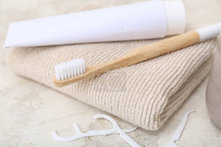 Foto de Cepillo de dientes de bambú, pasta, toallas y mondadientes de hilo dental sobre fondo claro, primer plano - Imagen libre de derechos