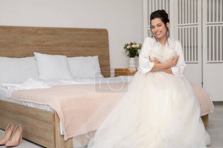 Foto de Joven novia con su vestido de novia sentado en el dormitorio - Imagen libre de derechos