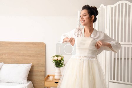 Foto de Joven novia con su vestido de novia en el dormitorio - Imagen libre de derechos