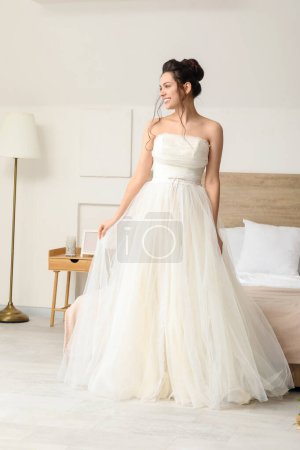 Foto de Joven novia usando su vestido de novia en el dormitorio - Imagen libre de derechos