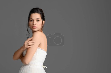 Foto de Hermosa novia joven en vestido de novia sobre fondo oscuro - Imagen libre de derechos