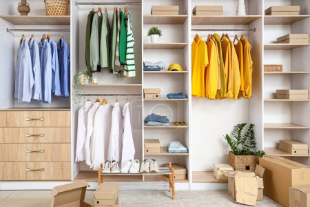 Photo for Interior of modern dressing room with wardrobe boxes, stylish clothes and accessories - Royalty Free Image