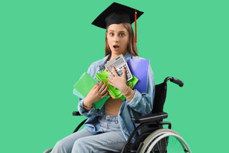 Photo for Shocked female graduate in wheelchair with copybooks and calculator on green background - Royalty Free Image
