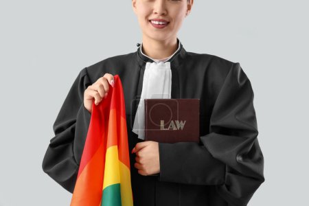 Photo for Female judge with LGBT flag and law book on light background, closeup - Royalty Free Image