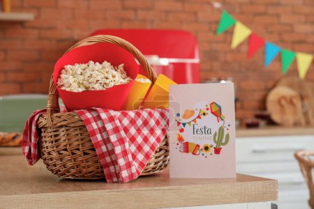 Wicket Korb mit Popcorn und Grußkarte auf dem Tisch in der Küche. Festa Junina