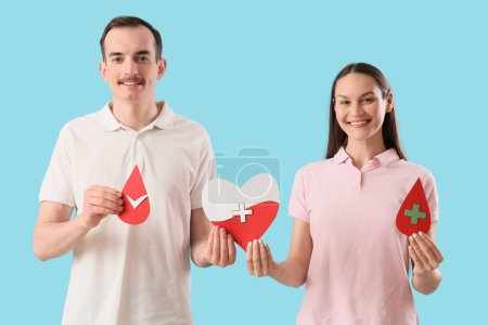 Blood donors with paper drops and heart on blue background