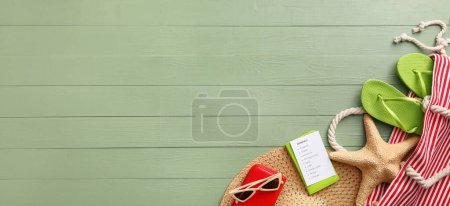 Téléchargez les photos : Carnet de notes avec check-list des choses à emballer pour voyager sur fond vert en bois avec espace pour le texte - en image libre de droit