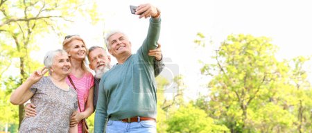Gruppe glücklicher Senioren macht Selfie im Park