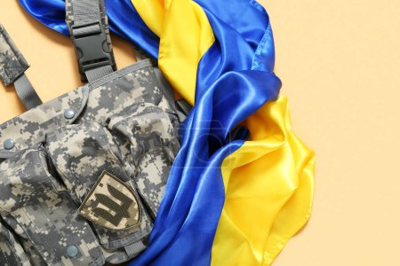 Déchargement gilet avec insigne de l'armée ukrainienne et le drapeau de l'Ukraine sur fond beige