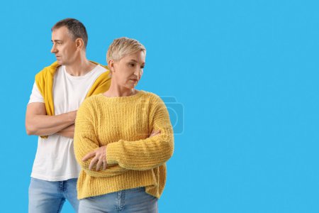 Offended mature couple on blue background