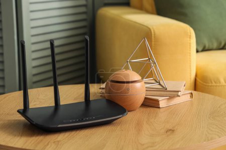 Moderne Wi-Fi-Router mit Büchern auf dem Tisch im Wohnzimmer, Nahaufnahme