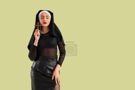 Sexy nun with cross on green background