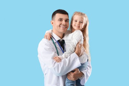 Male pediatrician and little girl on blue background