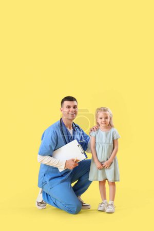 Male pediatrician with clipboard and little girl on yellow background