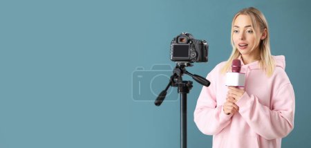 Female journalist with microphone recording video on blue background with space for text