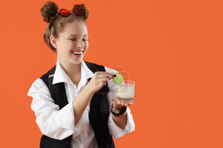 Barman femelle avec cocktail sur fond orange