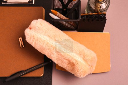 Photo for Pencil case, copybooks and pens on brown background - Royalty Free Image