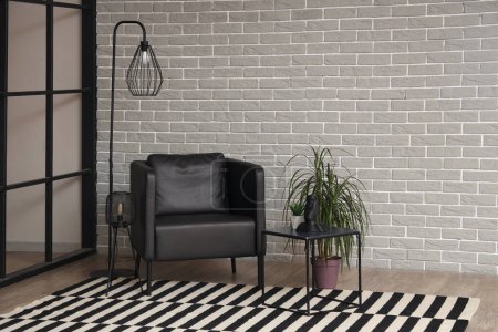 Téléchargez les photos : Interior of modern living room with black armchair, table and lamps - en image libre de droit