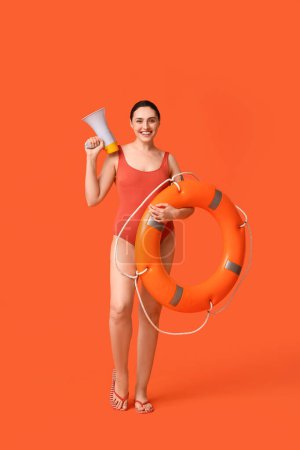 Photo for Female lifeguard with ring buoy and megaphone on orange background - Royalty Free Image