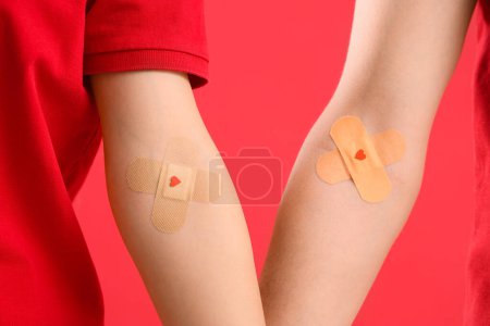 Blood donors with applied patches on red background, closeup