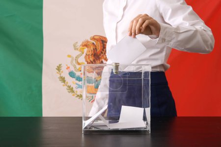 Votación de una mujer joven cerca de las urnas contra la bandera mexicana, primer plano