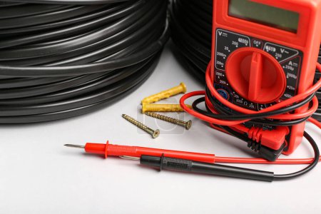 Photo for Multimeter, electric cable reels, dowels and screws on light background, closeup - Royalty Free Image