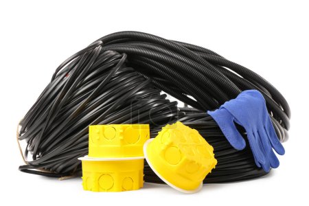 Rolled cables, flexible conduit tube, electrical junction boxes and fabric gloves on white background