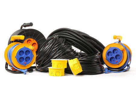 Rolled wires, flexible conduit tube, electrical junction boxes and extension cable reels on white background