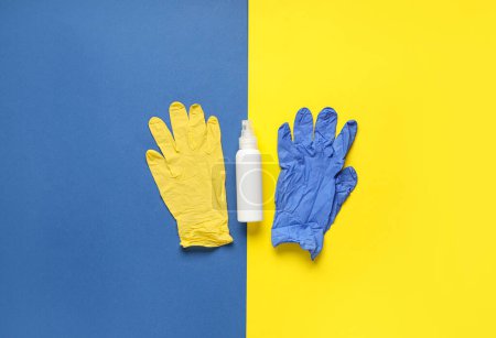 Flasche Desinfektionsmittel und Gummihandschuhe auf farbigem Hintergrund