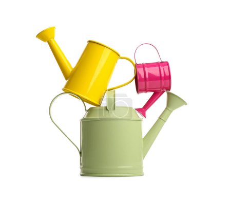 Color watering cans on white background