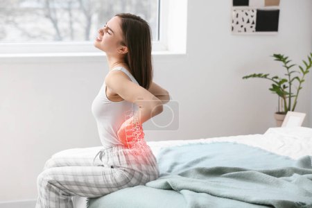 Junge Frau leidet unter Rückenschmerzen im Schlafzimmer