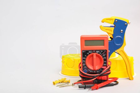 Photo for Set of electrician's tools with multimeter on light background - Royalty Free Image