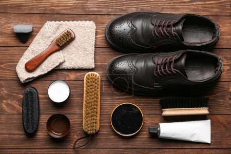 Set von Schuhputzwerkzeugen und Schuhen auf Holzgrund