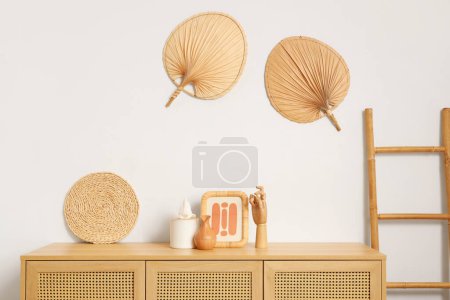 Holzhand mit Rahmen und Seidenschachtel auf Kommode im Wohnzimmer