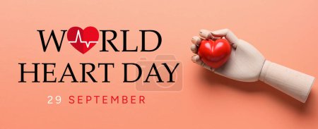 Mano de madera con corazón rojo sobre fondo de color. Banner para el Día Mundial del Corazón